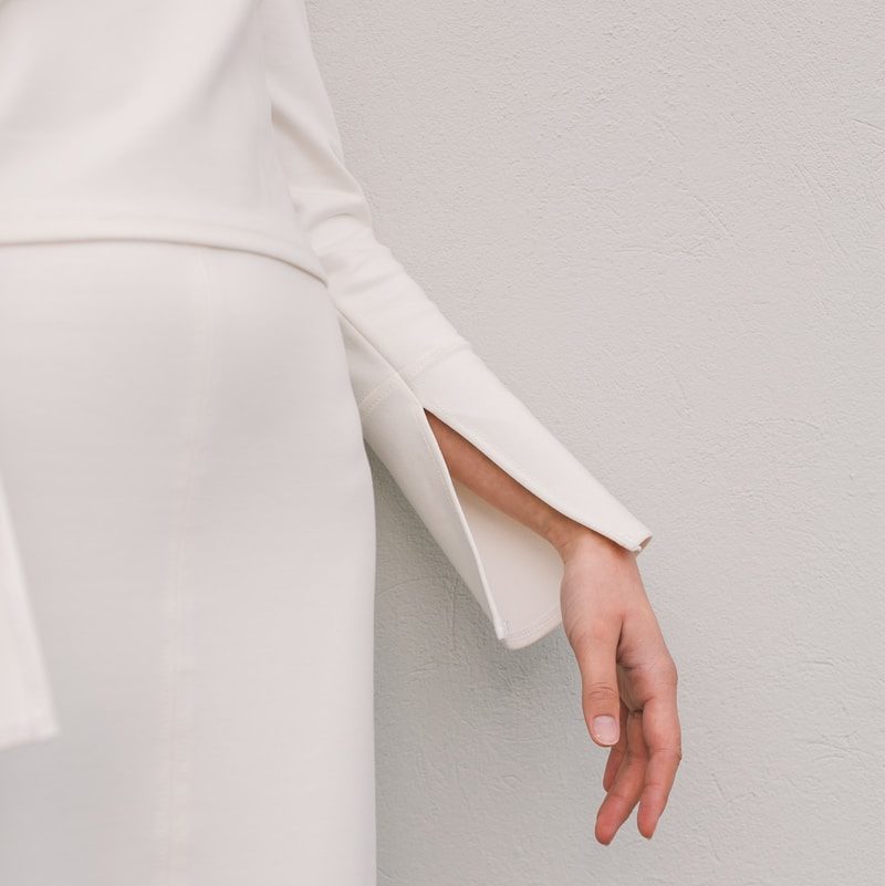 woman wearing pink dress while standing near black metal rail at daytime